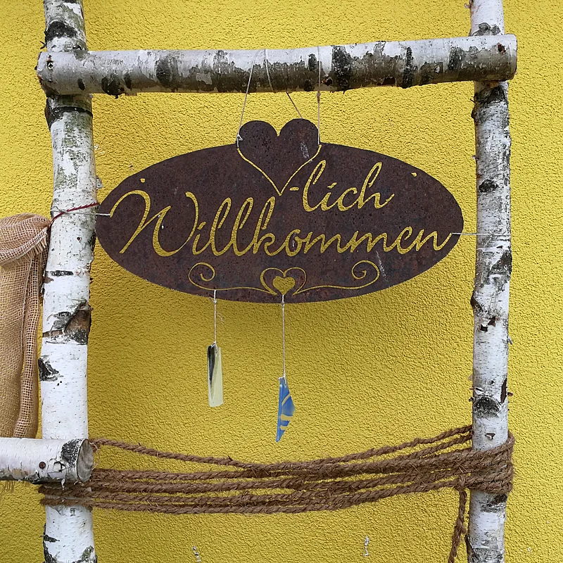 Bild Biberger_willkommen Willkommensschild mit Birkenastumrandung